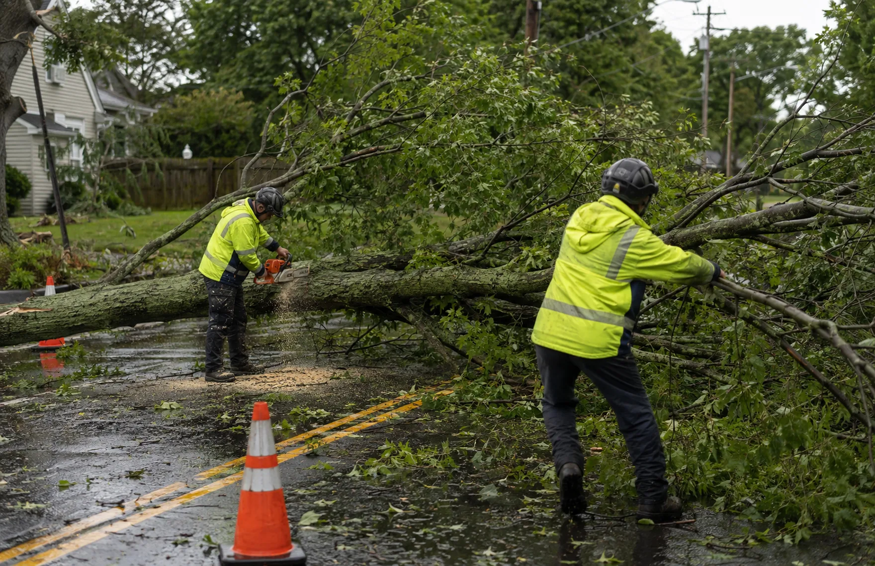 Crew performing emergency tree removal near a storm-damaged front yard in Evans - GA